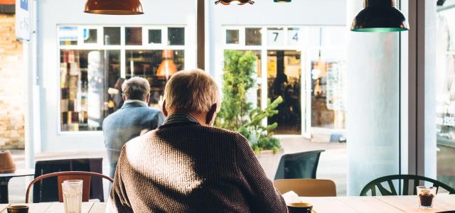 Man in coffee shop reading a newspaper